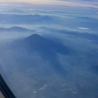 可能是飛機、暮光、霧、雲和山的圖像