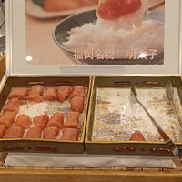 可能是 1 人、壽司、煙燻鮭魚、生魚片和顯示的文字是「福岡名物 福岡名物明素子 明本子」的圖像