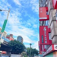 可能是 2 個人、街道、雲和顯示的文字是「背 夜 Xiao Yê AN RO -A Wig RLD FITNESS ORLD RLDGYM GYM 日北最博店 同放空間標示牌 PPNG 」的圖像
