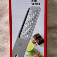 可能是‎巧克力棒、刀和‎顯示的文字是「‎究 ZWILLING ZWILLING Z-CUT MINI GRATER و lAK Minireibe Mini ើង Rellador mini Mini grattegia Minirasp Miniralador alador ews-1egs0 ミニグレーター 迷你创丝雅‎」‎‎ 的圖像