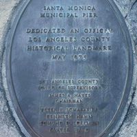 可能是紀念碑和顯示的文字是「 SANTA MONICA MUNICIPAL PIER DEDICATED DEDIC AN OFFICIAL LOS ANGELES COUNTY HISTORICAL LANDMARK MAY 1975 LO3 ANGELIS COUNTY BOARD OF SUPERVISOR JAMESA.HAYES JAMES HAYES GHAIRMAN 국학도 PyTEP E.SCHARARO KENNITH RAHN EDMUND D DILY BAKTER VARD 」的圖像