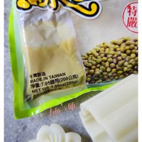 可能是豆腐和顯示的文字是「綠豆キ 豆 特 绿 嚴 DOA 台灣製造 MADEINTAIWAN 净重：7.05盘司（200公克) NETWT:7.050z(200 :7 TAIWAN 司（200公克） 7.05oz(200g) 20 MADE IN 7.05 淨 .05oz(200c) NET NETWT Lola Jola'slife life AR.Berlin AR. Berlin 」的圖像