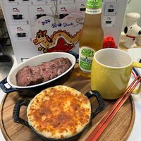 可能是牧羊人派、啤酒、肉排和文字的圖像
