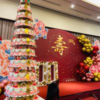 可能是‎婚禮蛋糕、洋桔梗和‎顯示的文字是「‎壽 100年 100 السد .涂金和先生‎」‎‎ 的圖像