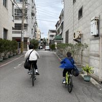 可能是 2 個人、自行車、街道和文字的圖像