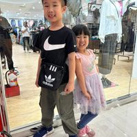 可能是 4 個人、嬰兒和顯示的文字是「 adidas adidas -2OUM 」的圖像