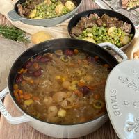 可能是燉小牛膝、豆煮玉米和顯示的文字是「 ravu STAUB A 5 0 TR SAIS 2 10 àd STAUB o y 」的圖像