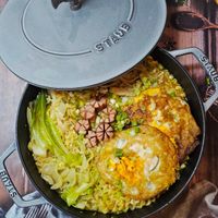 可能是西班牙大鍋飯、炒飯、蛋黃和顯示的文字是「 STAUB STAUR ህጊር SAUU a A 」的圖像