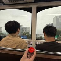 可能是 2 個人、火車、纜車和顯示的文字是「 나가는곳 아가는 」的圖像