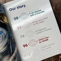 可能是顯示的文字是「 Our story. OOGOTTE 50 years of elevated It all started favor. Cocofte. with α 08 ሀክት STAUS 0000Y 3 STAUD 52 0000, STAUD 78 heart Our passion your table. Bring to the Ourtradition made in Indulgence France. artists. kiss Our culinary Chef's STAUB. for Oul Ourmarkets around America STAUB LRores the world. dPeUsA ppuK OOCOTTE STAU 96 STAU 112 」的圖形