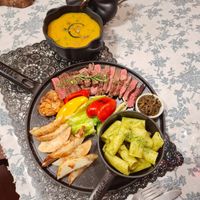 可能是起司火鍋、肉排和文字的圖像