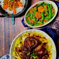 可能是北非小米飯、炒麵、燉小牛膝和肉排的圖像