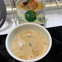 可能是粥、拉麵和顯示的文字是「調理參考 Suggested SuggestedServing Serving るで、 生めん。 豚骨 T Torkotsu 」的圖像