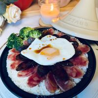 可能是肉排、水波蛋、炒飯、蛋黃和顯示的文字是「 STAUB STAUB STAUB AUB 」的圖像