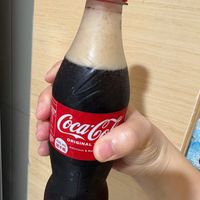 可能是飲料和顯示的文字是「 435 Coca-Co 35MORIGINAL 5mL ORIGINAL 海手斯 望 Deticious & Rer us 」的圖像