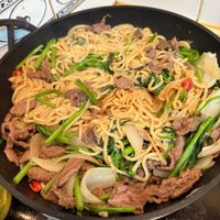 可能是炒麵、肉排和麵的圖像