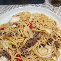 可能是炒麵、肉排、義大利麵和文字的圖像