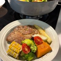 可能是肉排、燉小牛膝、豆煮玉米和文字的圖像