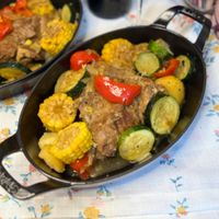 可能是肉排、燉小牛膝和豆煮玉米的圖像