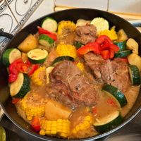 可能是肉排、豆煮玉米和燉小牛膝的圖像