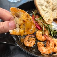 可能是西班牙大鍋飯、蝦和法式長棍麵包的圖像