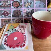 可能是咖啡杯、小徽章、日記、薑餅和文字的圖像