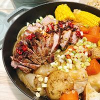可能是火鍋、肉排、豆煮玉米和文字的圖像