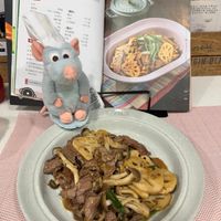 可能是義大利麵、肉排和文字的圖像