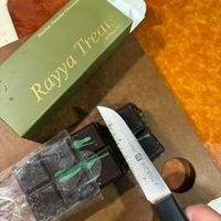 可能是刀和顯示的文字是「 Bar Chocolate Pistachio Treats aia Hazelnut นก็น Rasit 8 Rayya Rayya 」的圖像