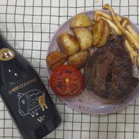 可能是香檳、肉排和文字的圖像