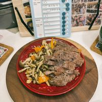 可能是肉排、義大利麵和文字的圖像