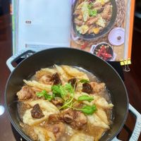 可能是火鍋、燉小牛膝、香菇、豆腐和文字的圖像