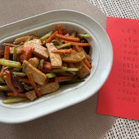 可能是炒麵、快炒、豆腐和文字的圖像