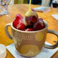 可能是起司火鍋、咖啡杯、甜點、草莓和顯示的文字是「 SIAUB STAUB 」的圖像