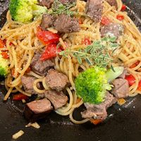 可能是快炒、義大利麵和肉排的圖像