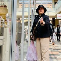 可能是一或多人、牛角扣大衣和街道的圖像
