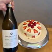 可能是草莓、蛋糕、香檳和顯示的文字是「 DUCHESSALIA DUCHE MOSCATODASTI IeN 2021 MOSCATO DASTI 1A0NE e 」的圖像