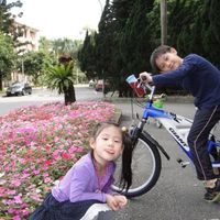 可能是小孩、速克達和自行車的圖像