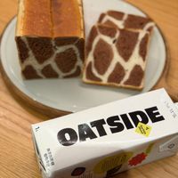 可能是顯示的文字是「 ٦1 OATSIDE Bea OatM1%k Oat M'lk Blend Barist g 植物限分 無添加萨糖」的圖像