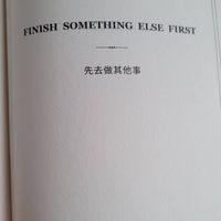 可能是書籍和顯示的文字是「 FINISH SOMETHING ELSE ELSE FIRST FIRST 先去做其他事」的圖像