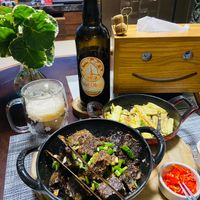 可能是啤酒、燉小牛膝、肉排、起司火鍋、豆腐和文字的圖像